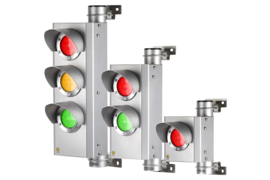 Drie metalen verkeerslichten van verschillende hoogtes, elk met rode, gele en groene lichten. De lichten zijn gemonteerd op rechthoekige behuizingen met beschermkappen en beugels voor bevestiging. De achtergrond is effen wit.
