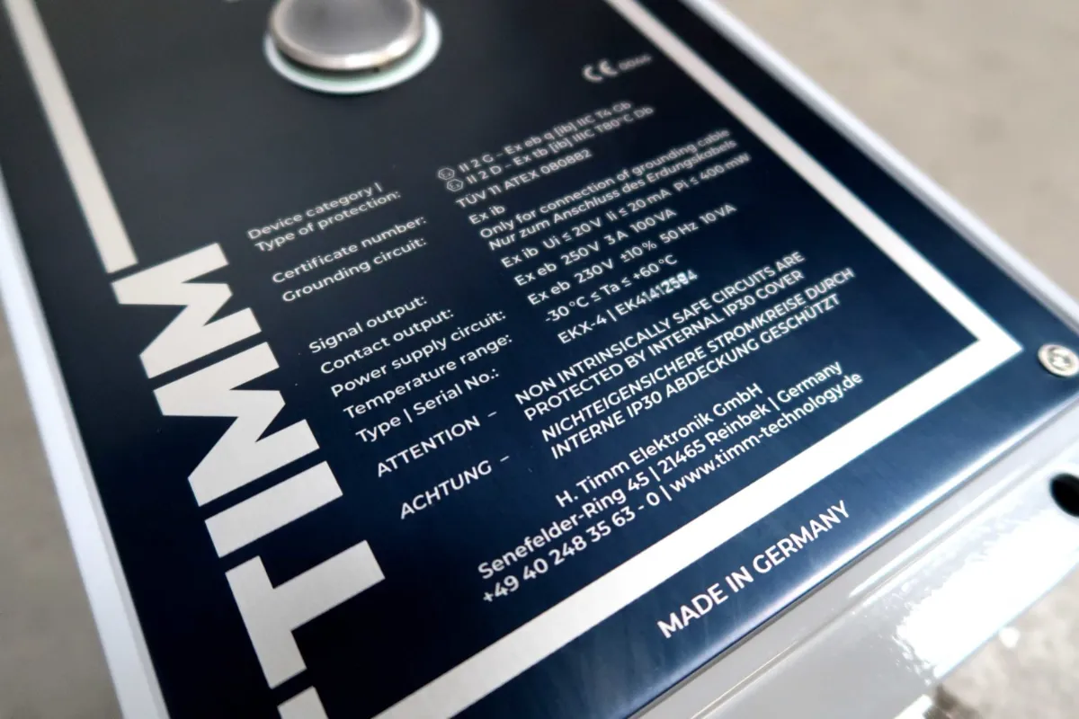Close-up van een apparaatlabel met technische specificaties, certificeringsgegevens, veiligheidswaarschuwingen en informatie over de fabrikant. Het label is grotendeels in het Engels en Duits opgesteld. Onderaan staat de tekst „MADE IN GERMANY“.