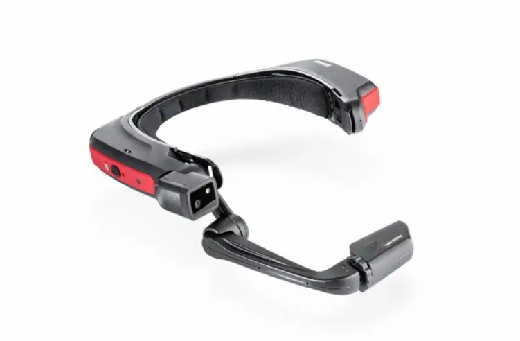 Een draagbaar headsetapparaat met een zwart-rood ontwerp, voorzien van een camera en een scherm die aan een verstelbare arm zijn bevestigd, afgebeeld tegen een witte achtergrond.
