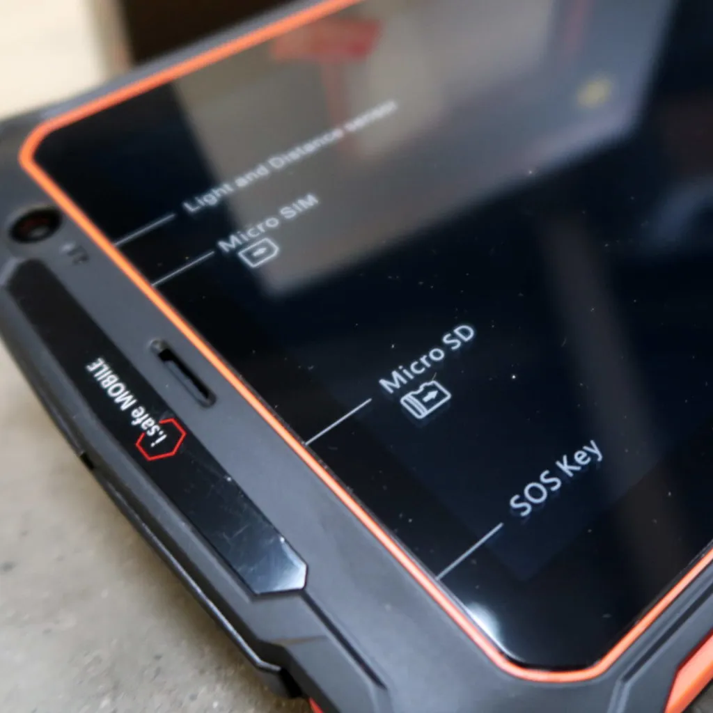 Close-up van een robuust mobiel apparaat met gelabelde sleuven voor een micro-simkaart, een micro-SD-kaart en een SOS-knop, met een zichtbaar ‘Lift Mobile’-lipje.